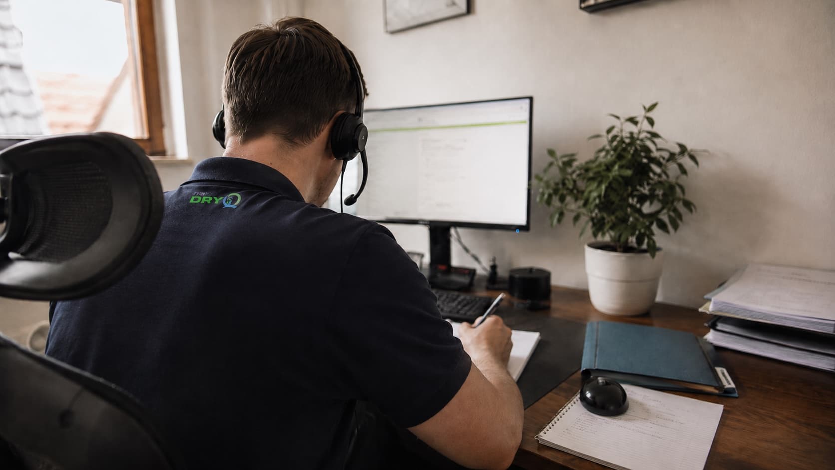 [FOTO: Mitarbeiter mit Headset am Telefon]